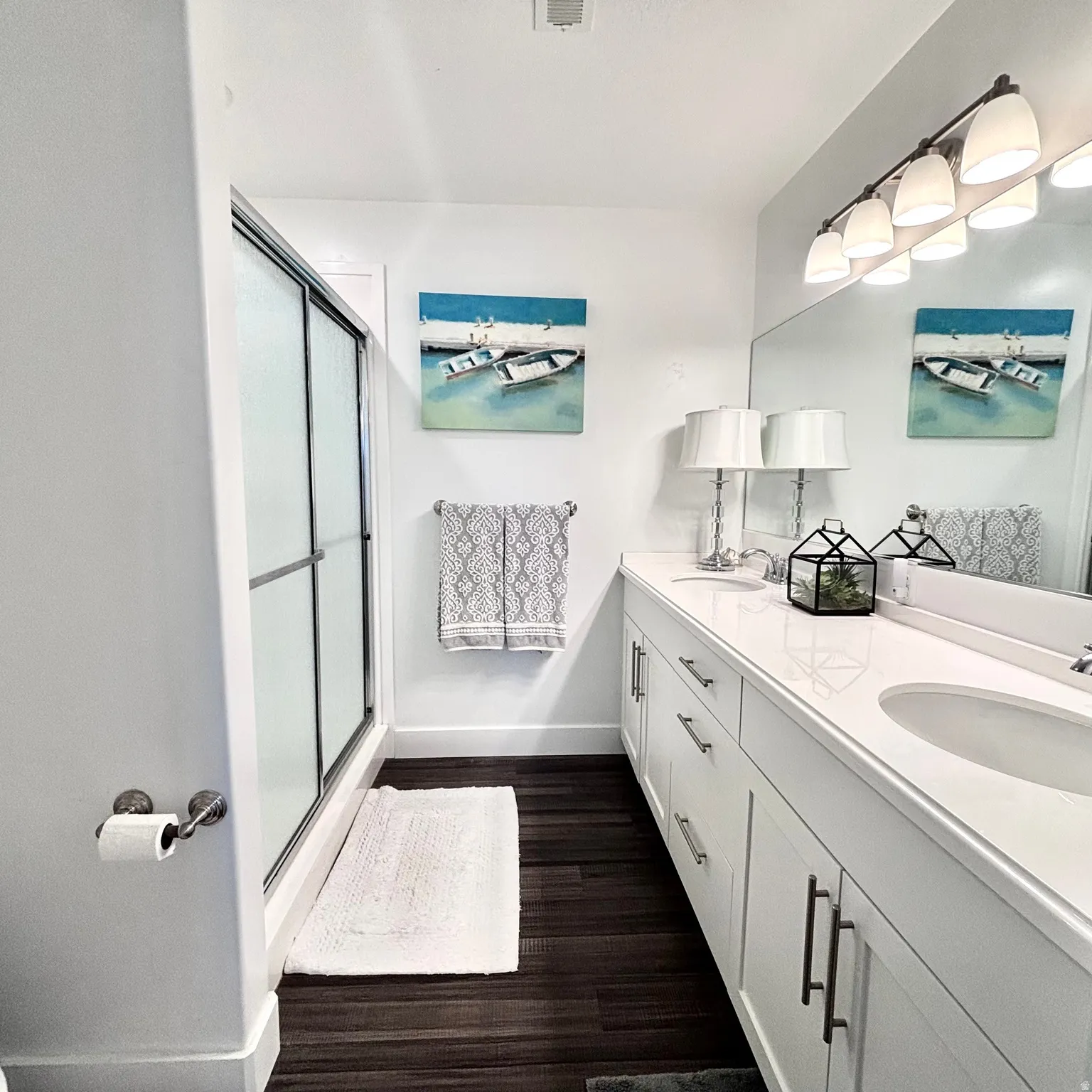 Well-appointed primary ensuite bath with double vanity, abundant storage, and a spacious & convenient walk-in shower.