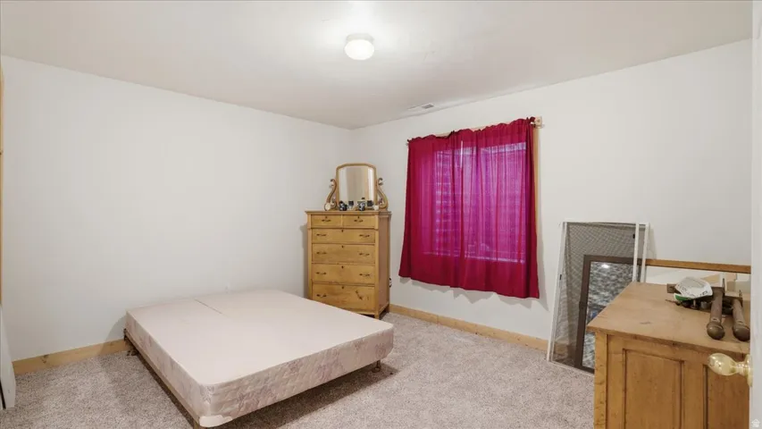 Bedroom featuring light colored carpet and baseboards