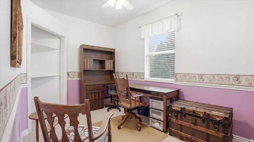 Office area with light carpet and ceiling fan