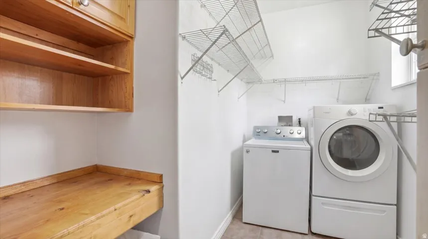 Laundry room featuring washer and clothes dryer and baseboards