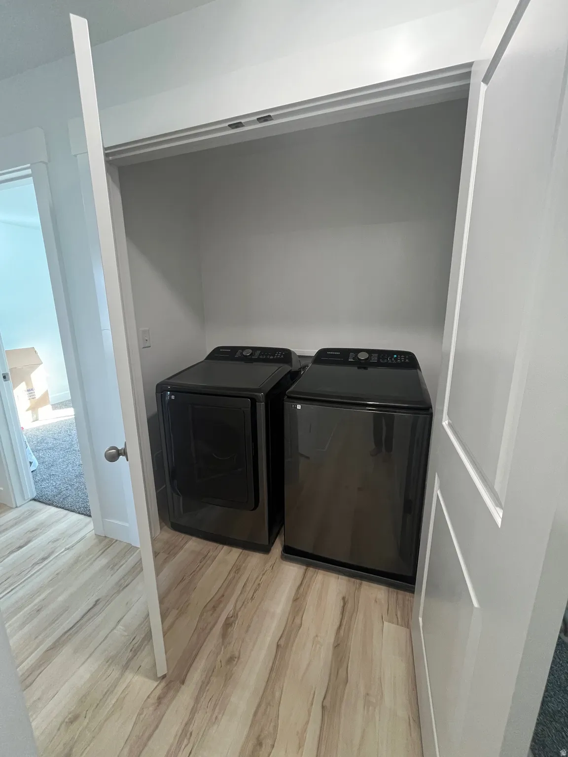 Laundry room featuring light wood-style floors and washing machine and clothes dryer