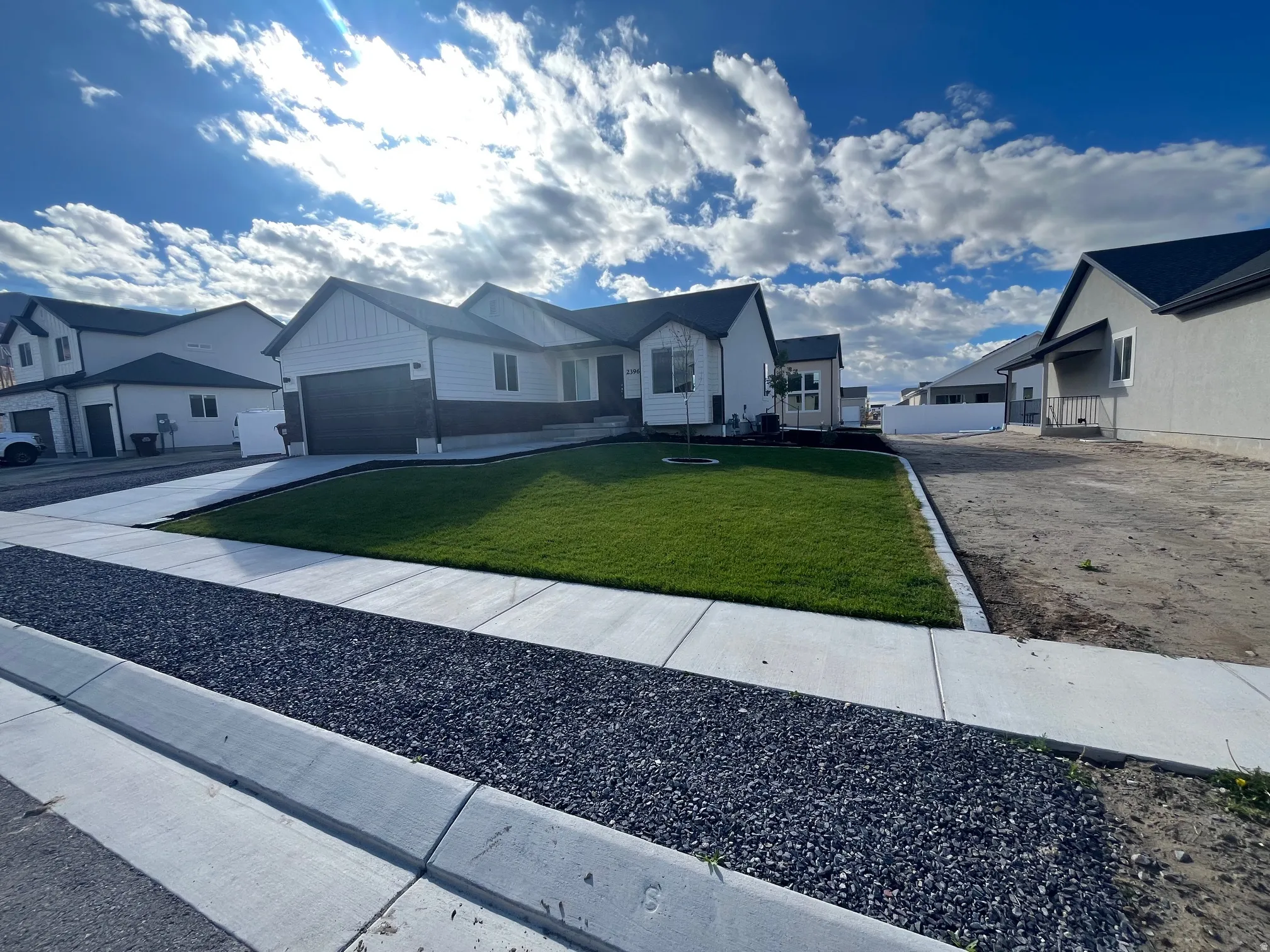 Single story home featuring an attached garage, a residential view, board and batten siding, and concrete driveway