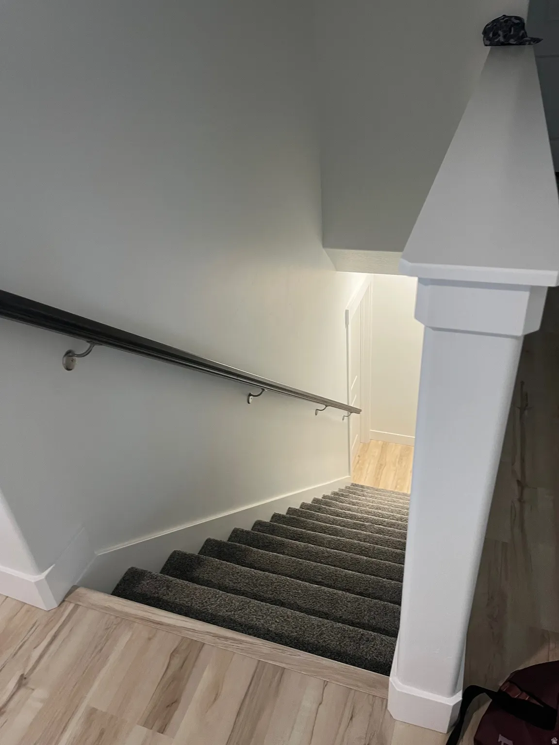 Stairway with wood finished floors and baseboards