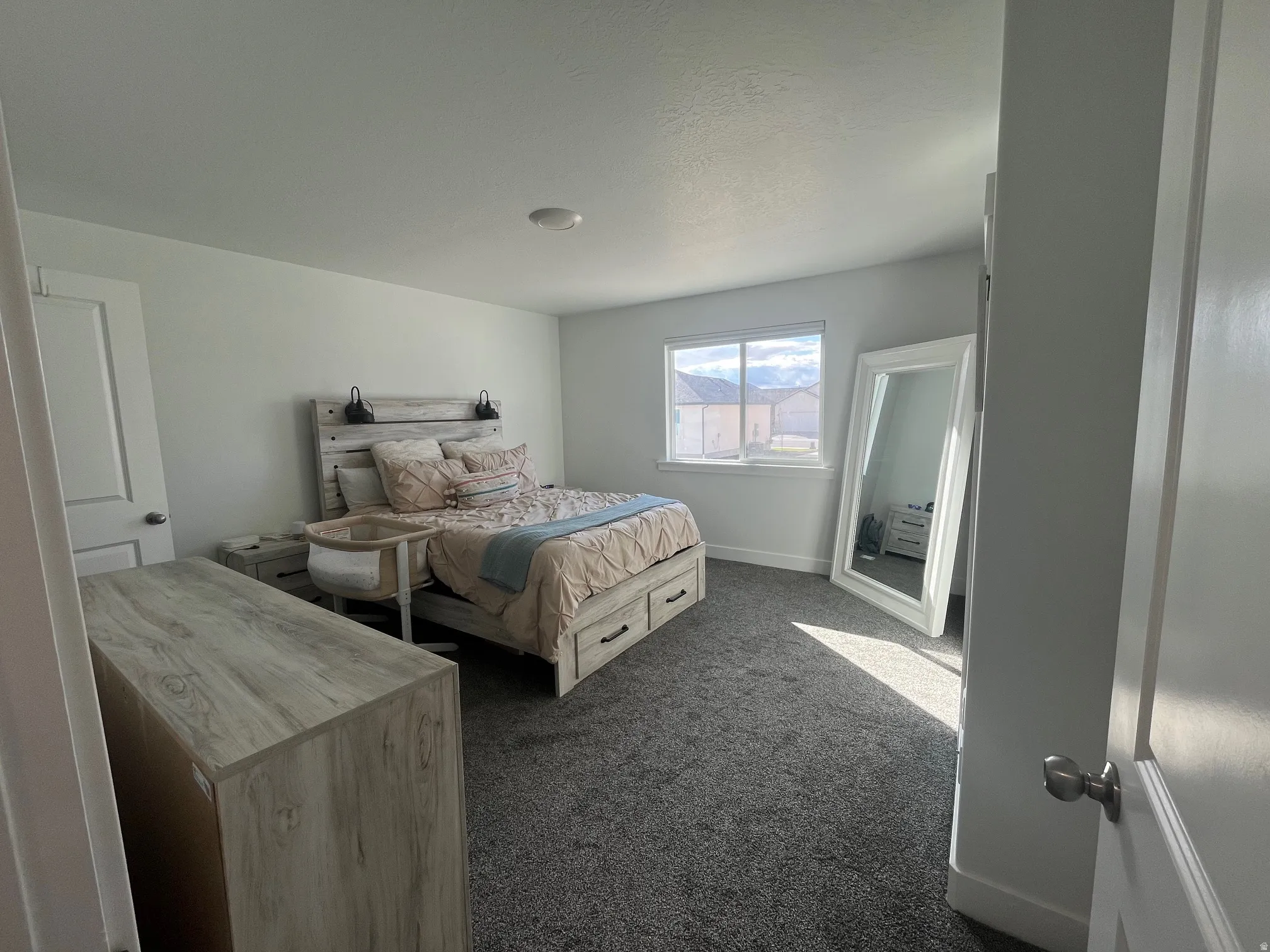 Bedroom featuring dark colored carpet and baseboards
