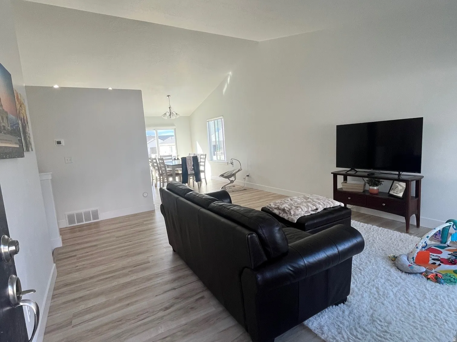 Living room with vaulted ceiling and light wood-type flooring