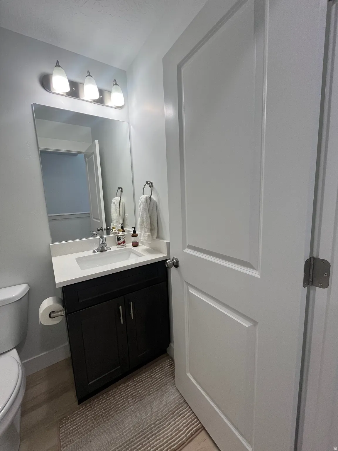 Half bathroom with vanity and light wood-type flooring