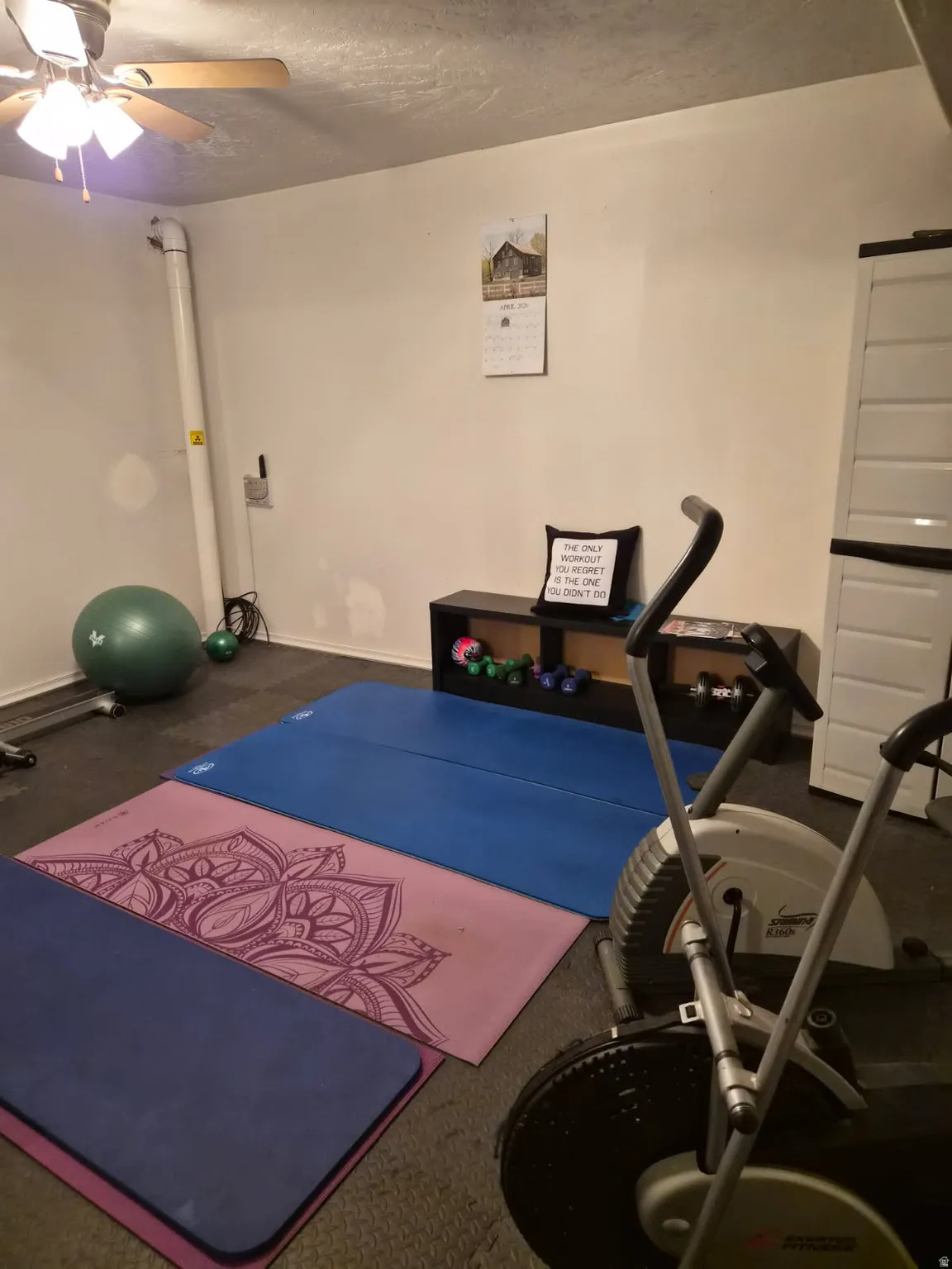 Exercise area with a ceiling fan and baseboards