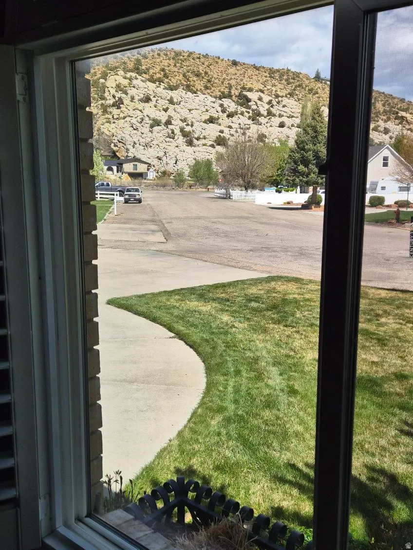View of grassy yard with a mountain view