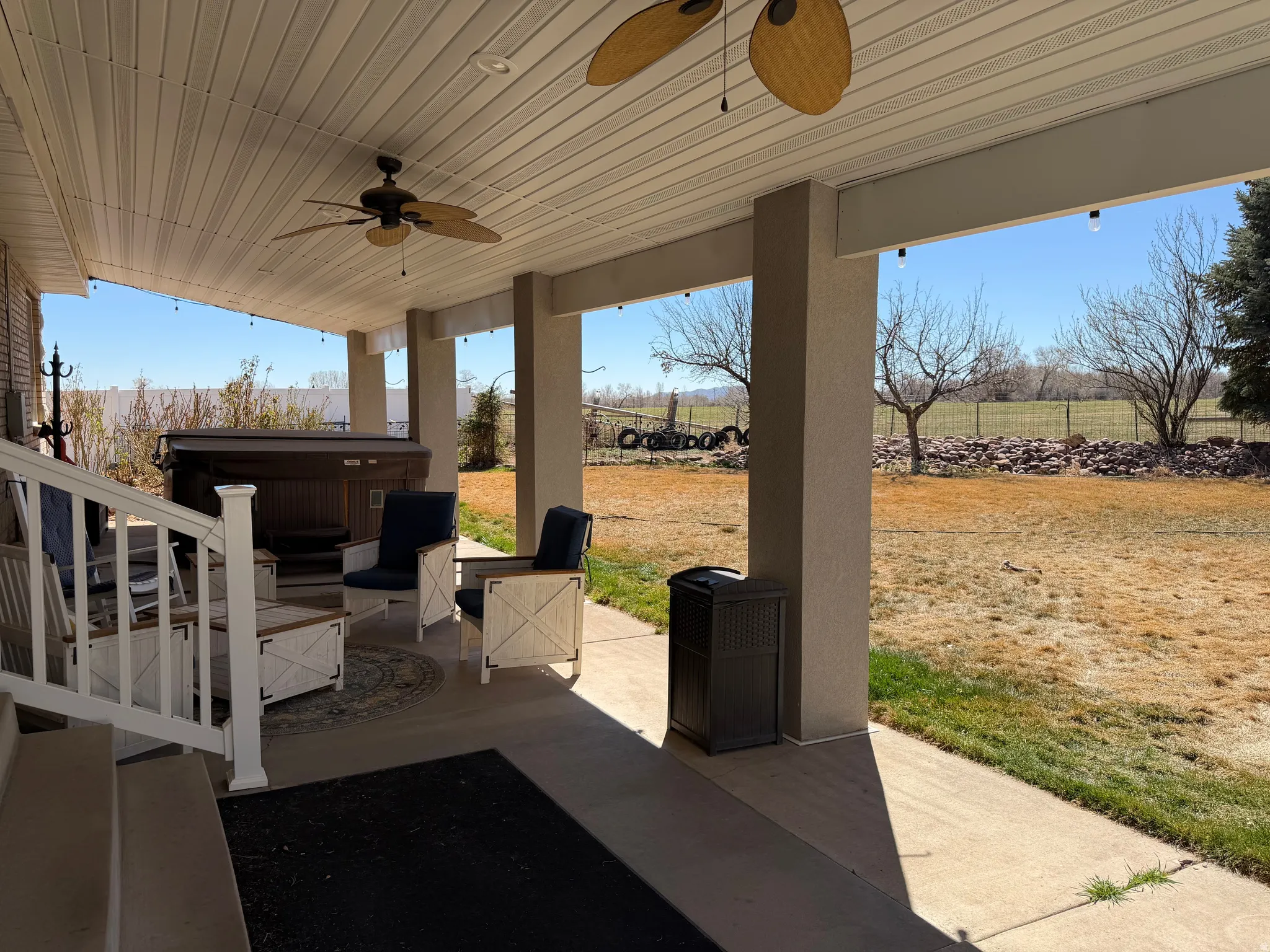 View of patio featuring ceiling fan and a hot tub