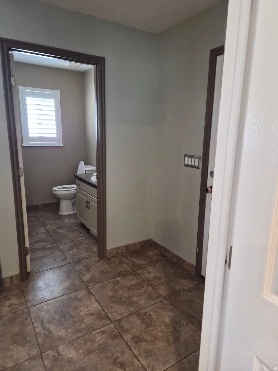 Bathroom featuring vanity and dark tile patterned floors