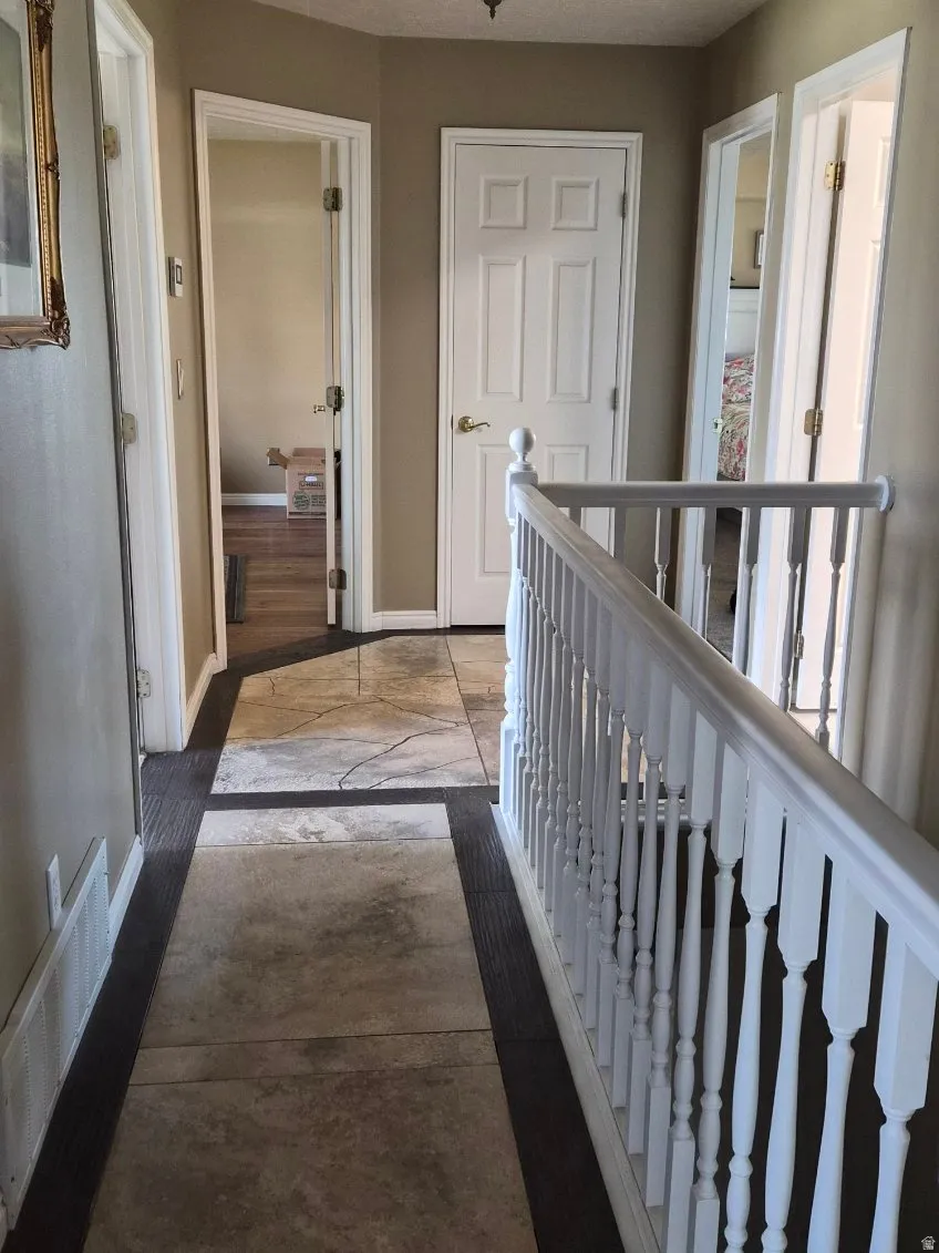 Hallway with baseboards and an upstairs landing