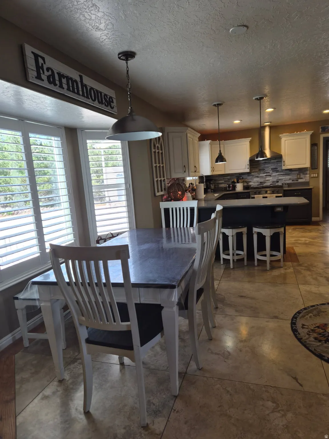 Dining room featuring recessed lighting, a textured ceiling, and concrete flooring