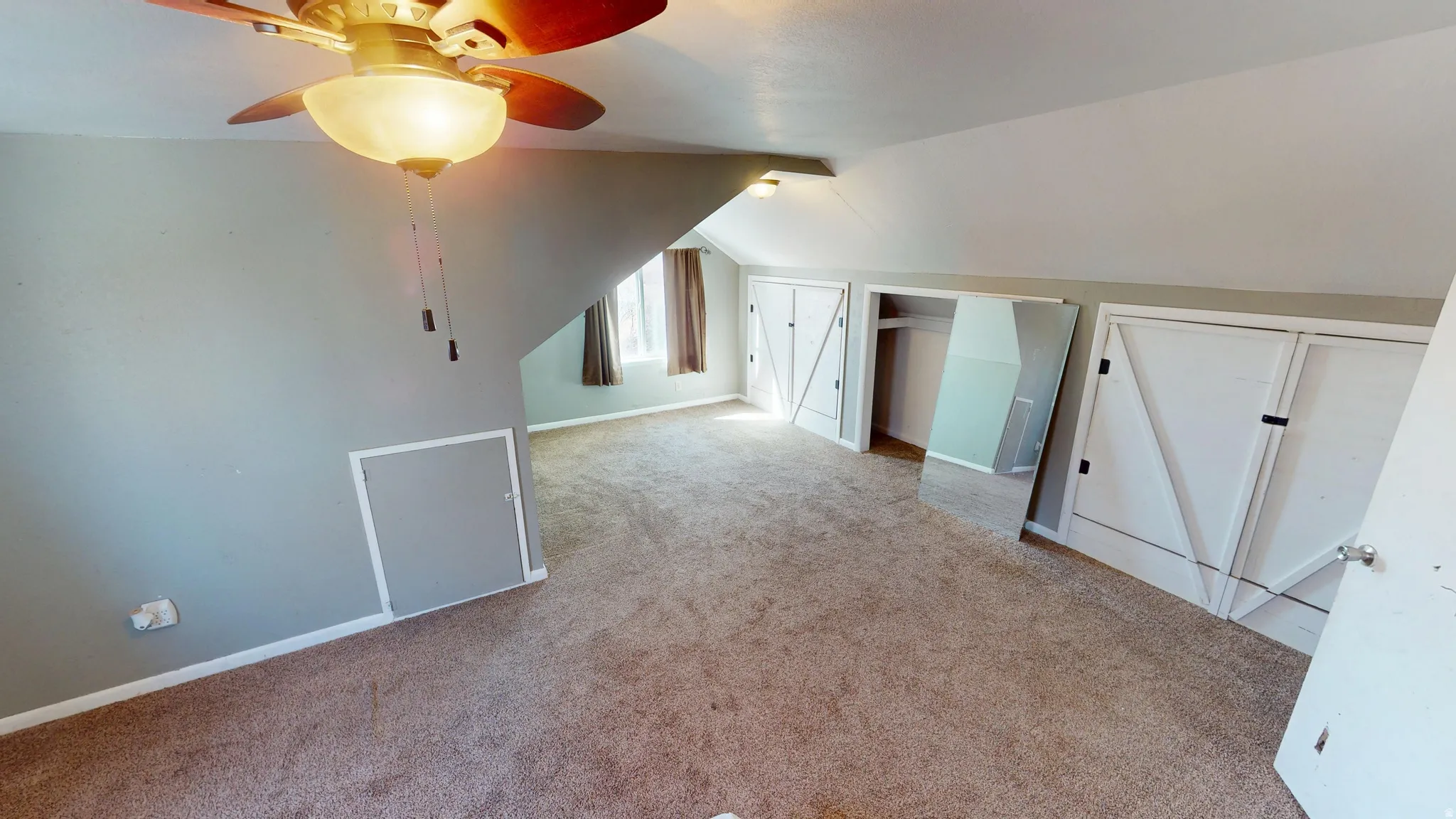 Additional living space with a ceiling fan, lofted ceiling, and light carpet