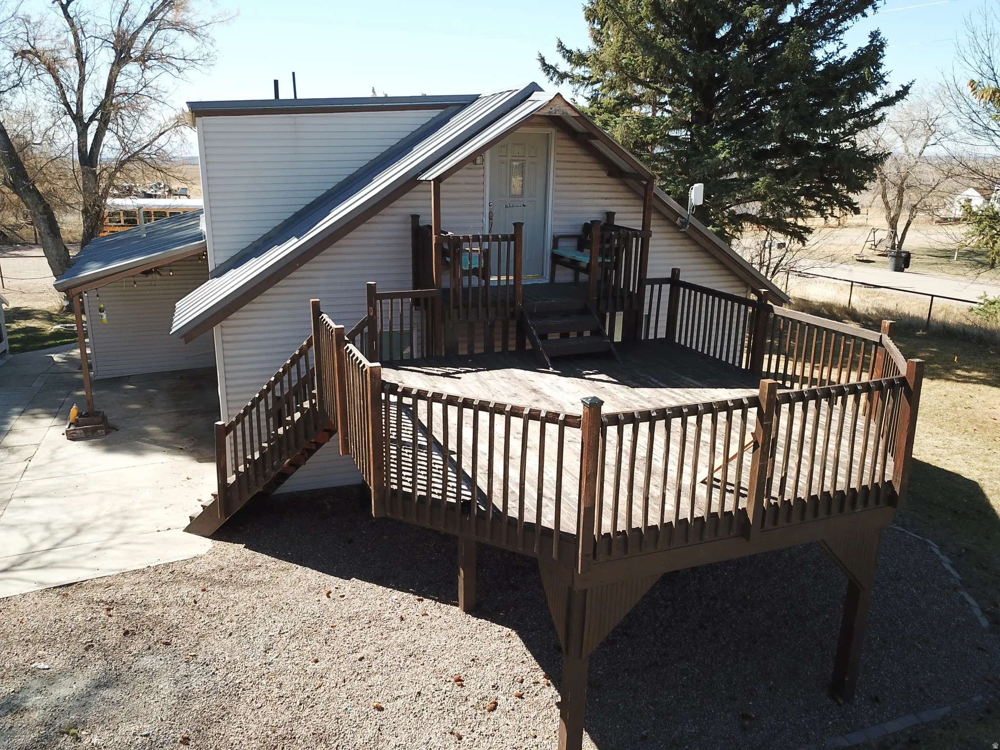 Back of house with a wooden deck and stairs