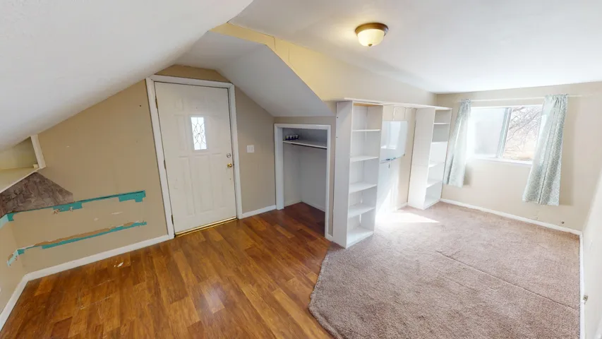 Additional living space with baseboards and wood finished floors