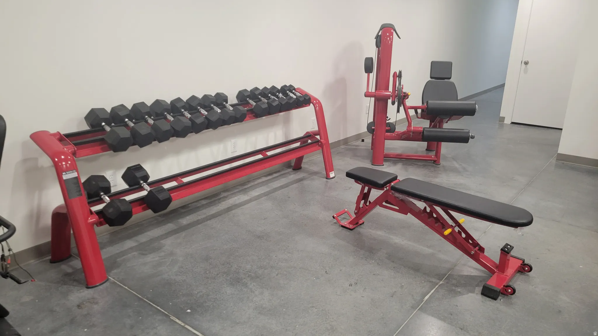 Exercise area featuring finished concrete flooring and baseboards