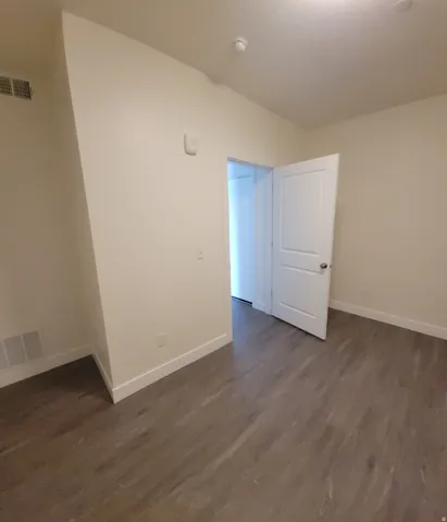 Unfurnished room featuring dark wood-style flooring
