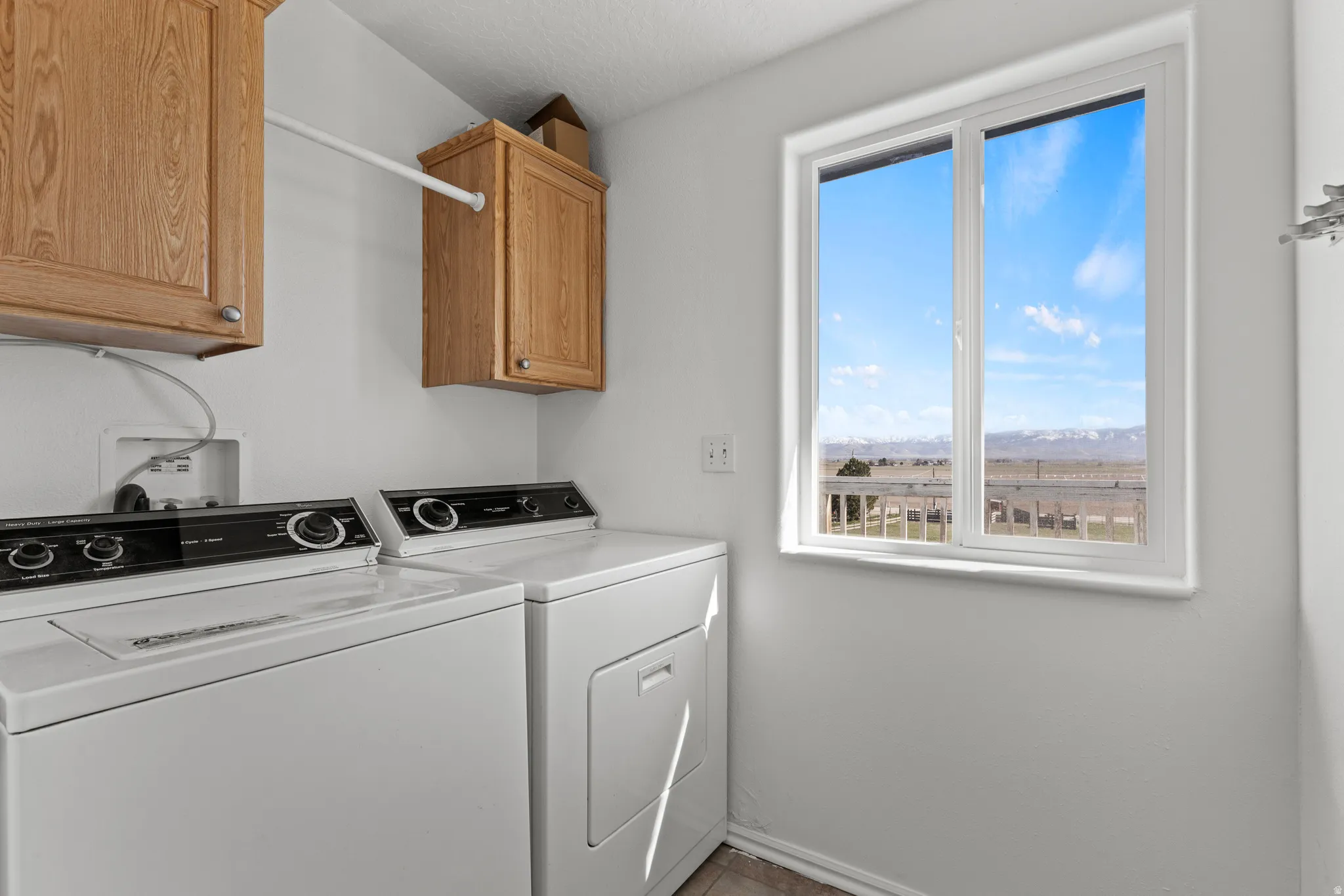 Laundry area with separate washer and dryer and cabinet space
