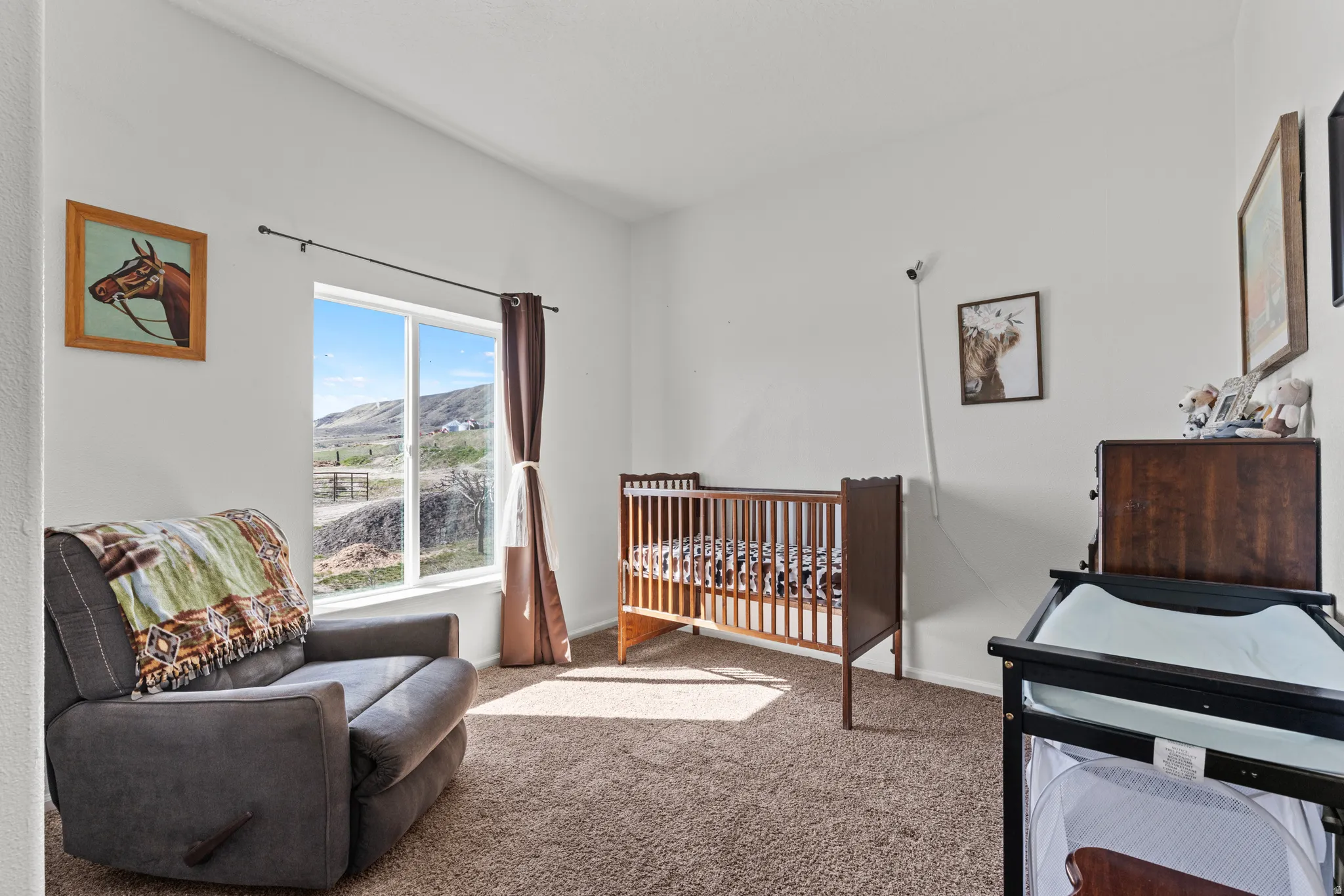 Carpeted bedroom featuring a crib and a mountain view