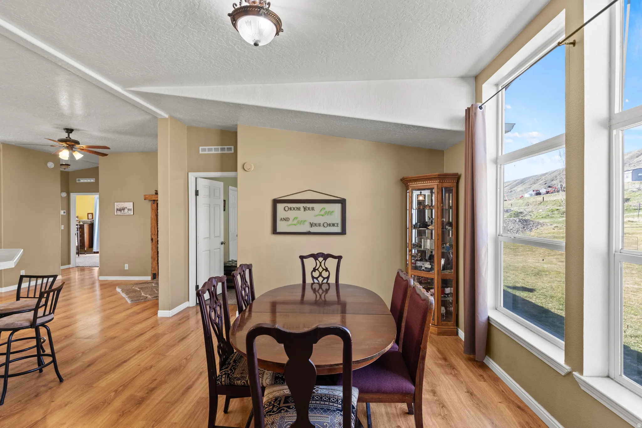 Dining area featuring light wood-style flooring, ceiling fan, and a mountain view