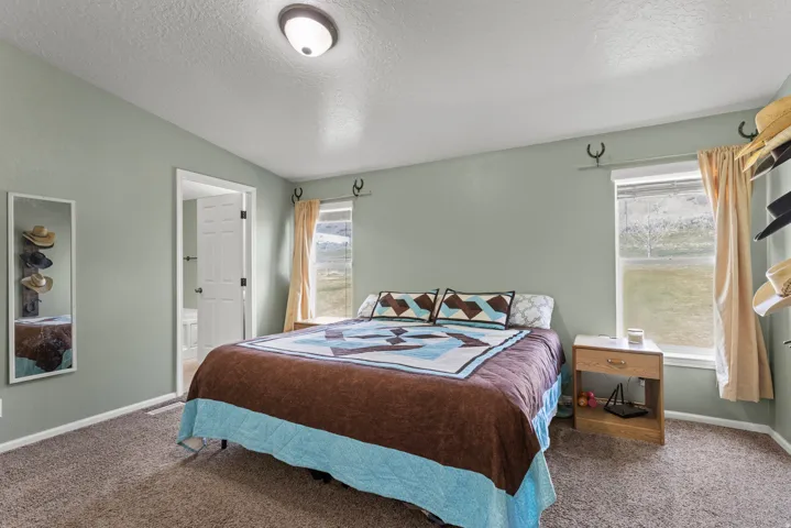 Carpeted bedroom featuring baseboards and connected bathroom