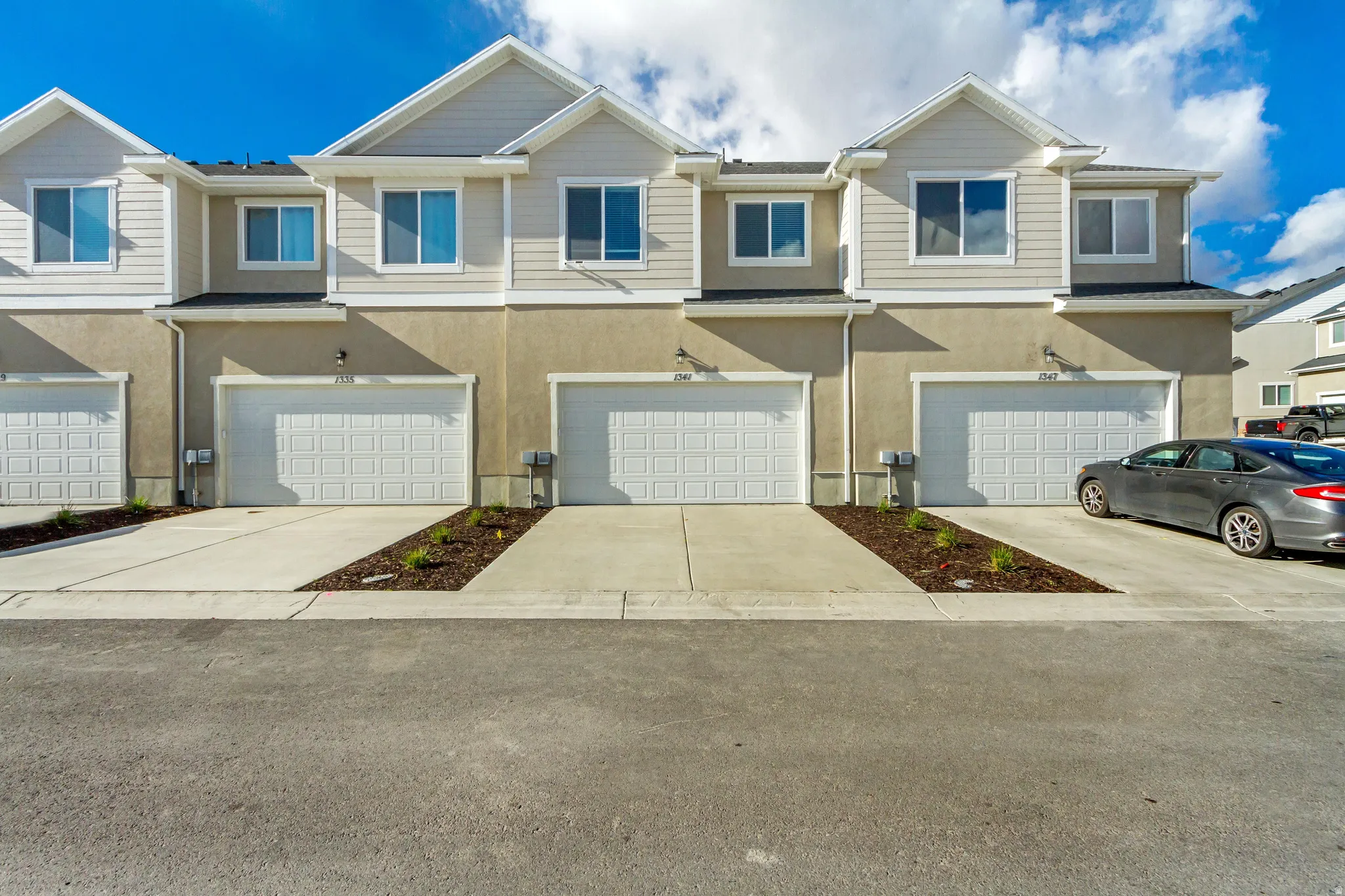 View of front of house featuring stucco siding, an attached garage, and driveway