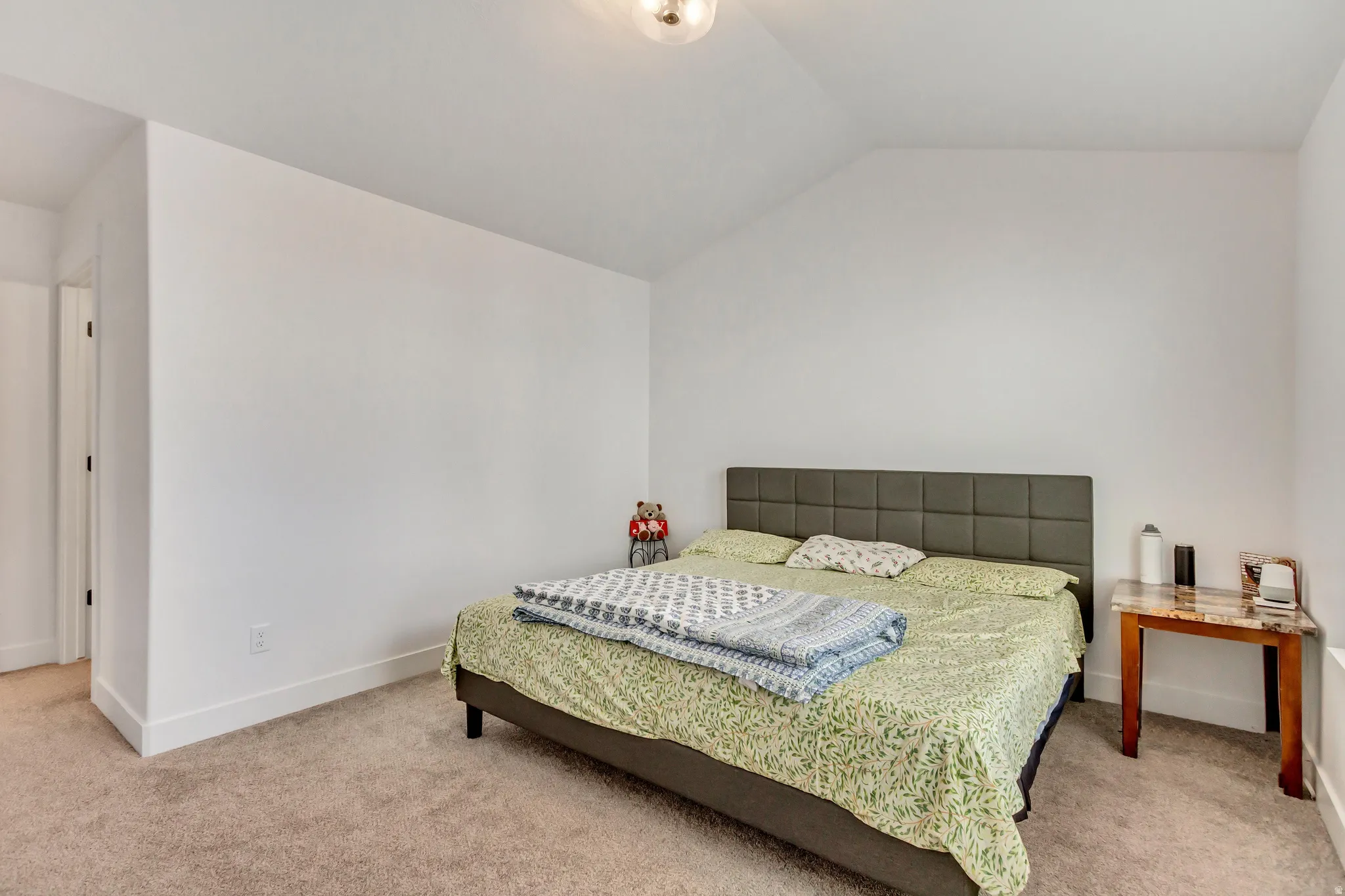 Bedroom featuring light colored carpet and lofted ceiling