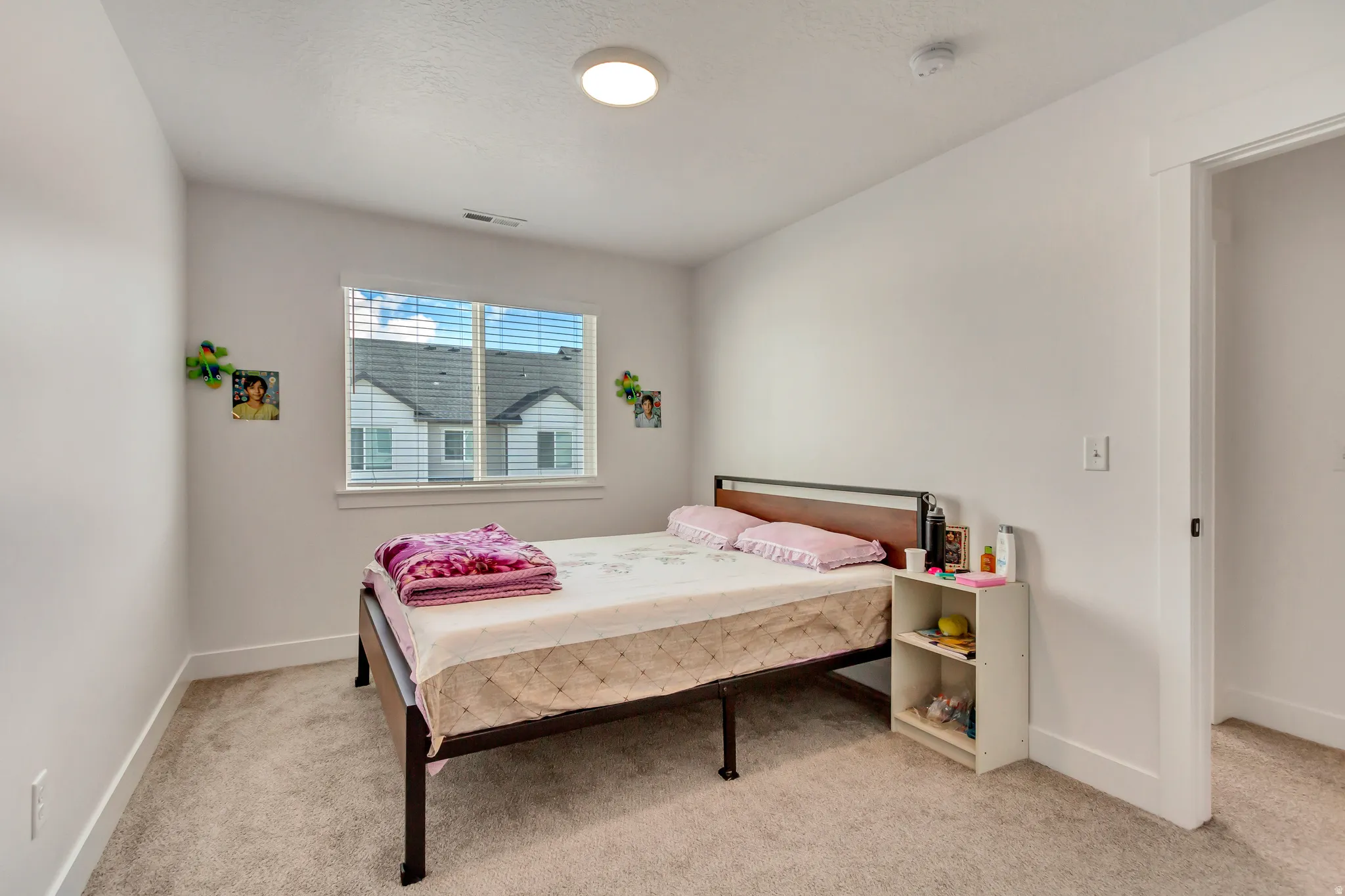 Bedroom with light colored carpet and baseboards