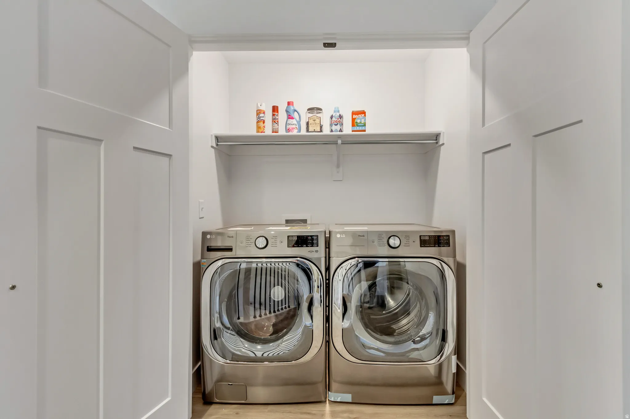 Laundry area with washer and clothes dryer and light wood finished floors