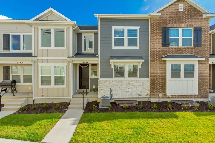 Craftsman house with board and batten siding, a front lawn, and stone siding