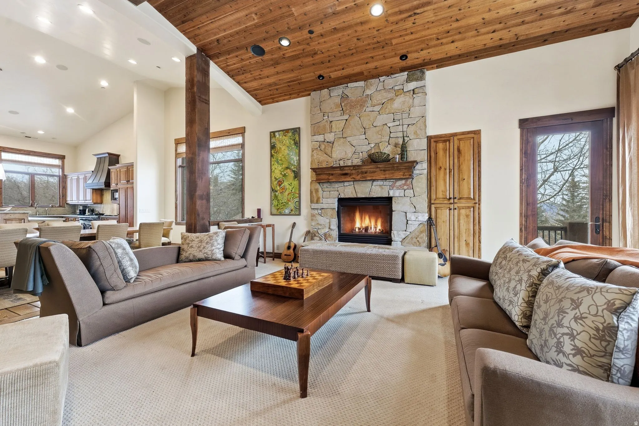 Living area with a vaulted wood ceiling, a stone fireplace, recessed lighting, and carpet