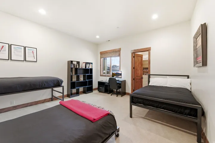 Carpeted bedroom with an office area and recessed lighting