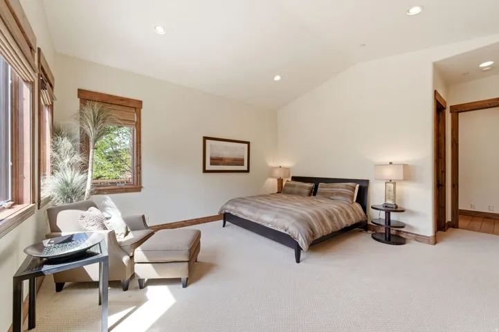 Bedroom featuring light colored carpet, vaulted ceiling, and recessed lighting