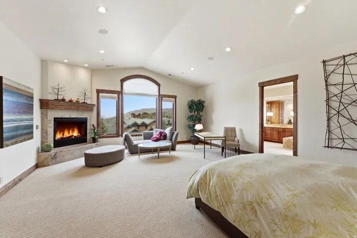 Bedroom with a tile fireplace, carpet flooring, ensuite bath, and recessed lighting
