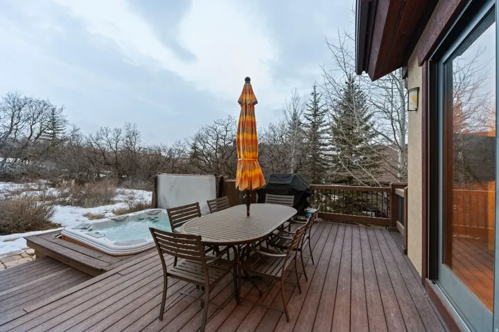 Snow covered deck featuring outdoor dining area and a grill