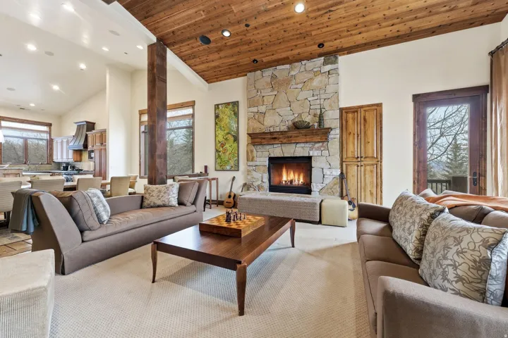 Living area with a vaulted wood ceiling, a stone fireplace, recessed lighting, and carpet