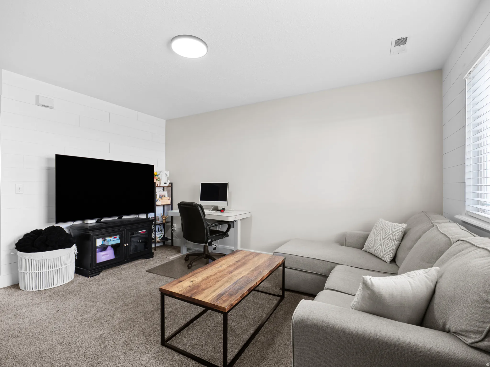 Carpeted living area with a desk