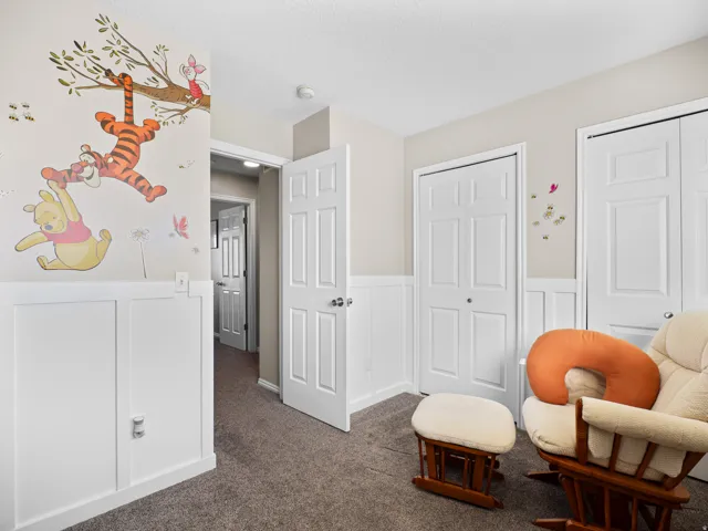 Sitting room featuring a wainscoted wall, a decorative wall, and dark carpet