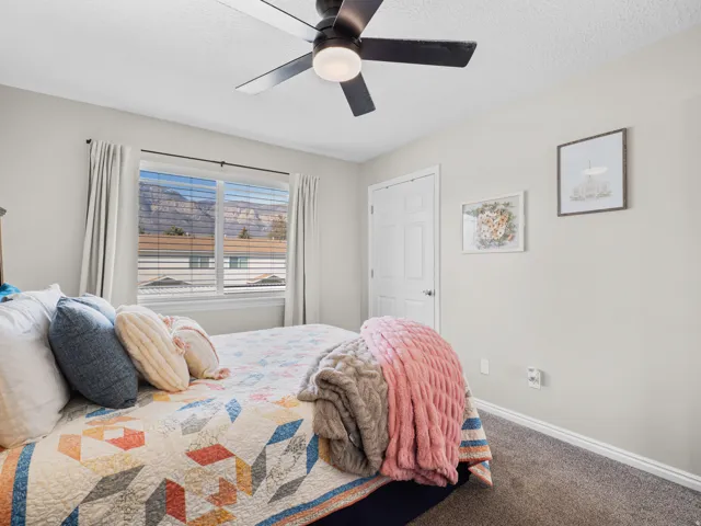 Carpeted bedroom with a ceiling fan and a textured ceiling