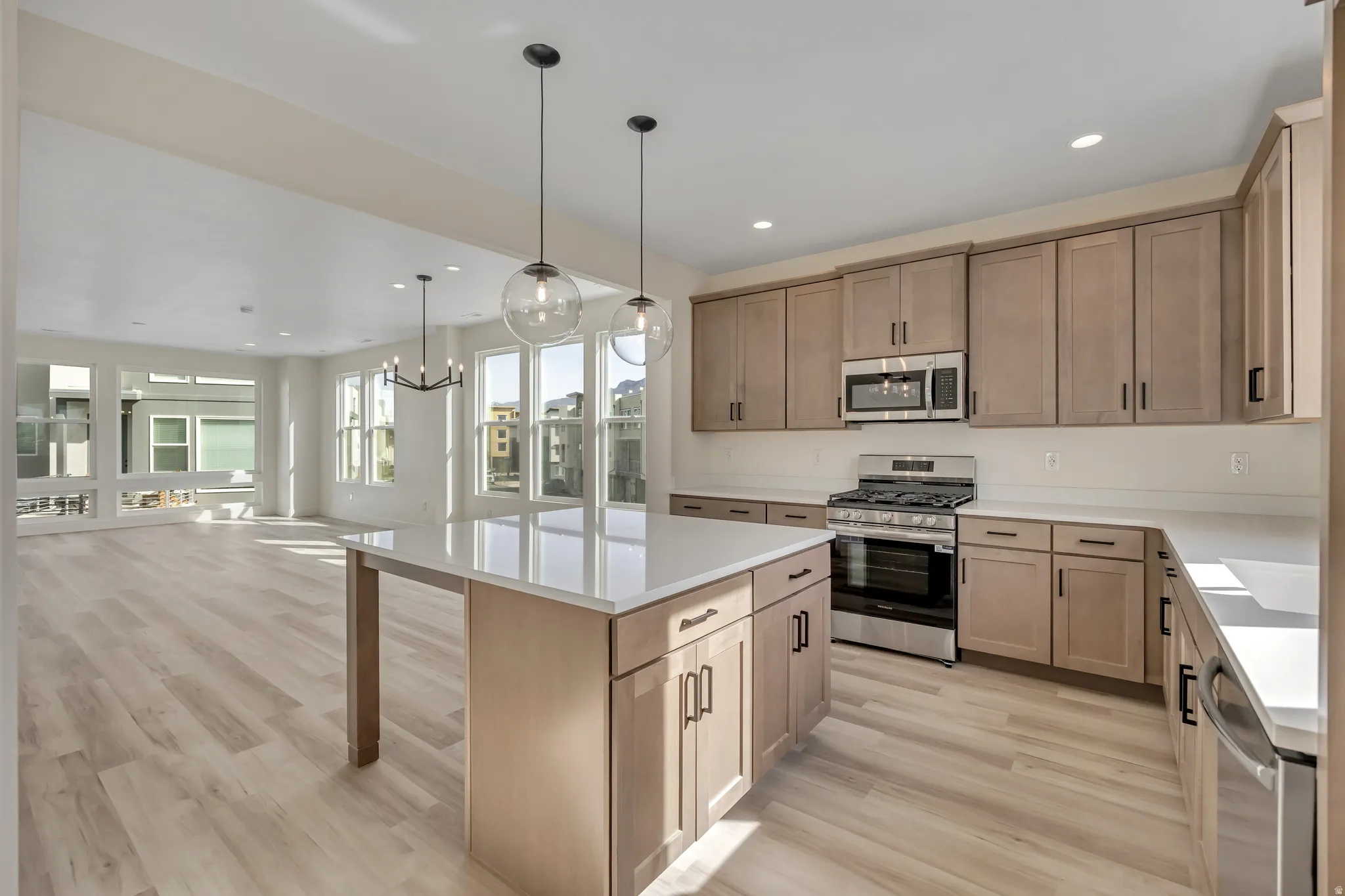 Kitchen with stainless steel appliances, open floor plan, light wood-style flooring, a center island, and a breakfast bar