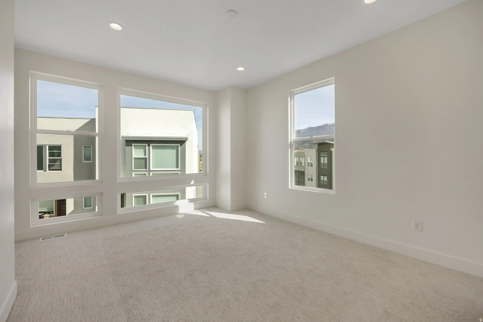 Carpeted spare room with baseboards and recessed lighting