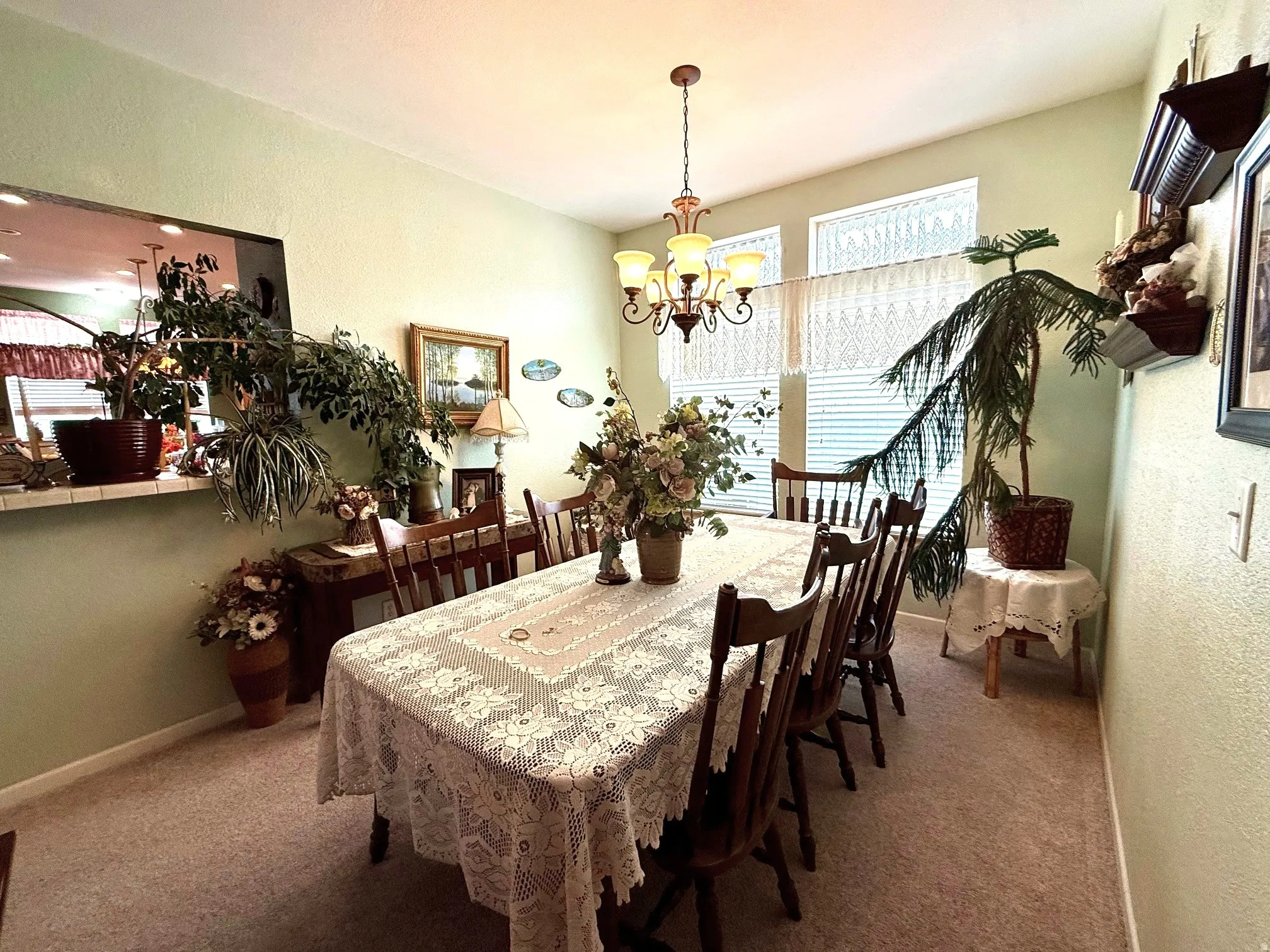 Carpeted dining room with a textured wall and a chandelier