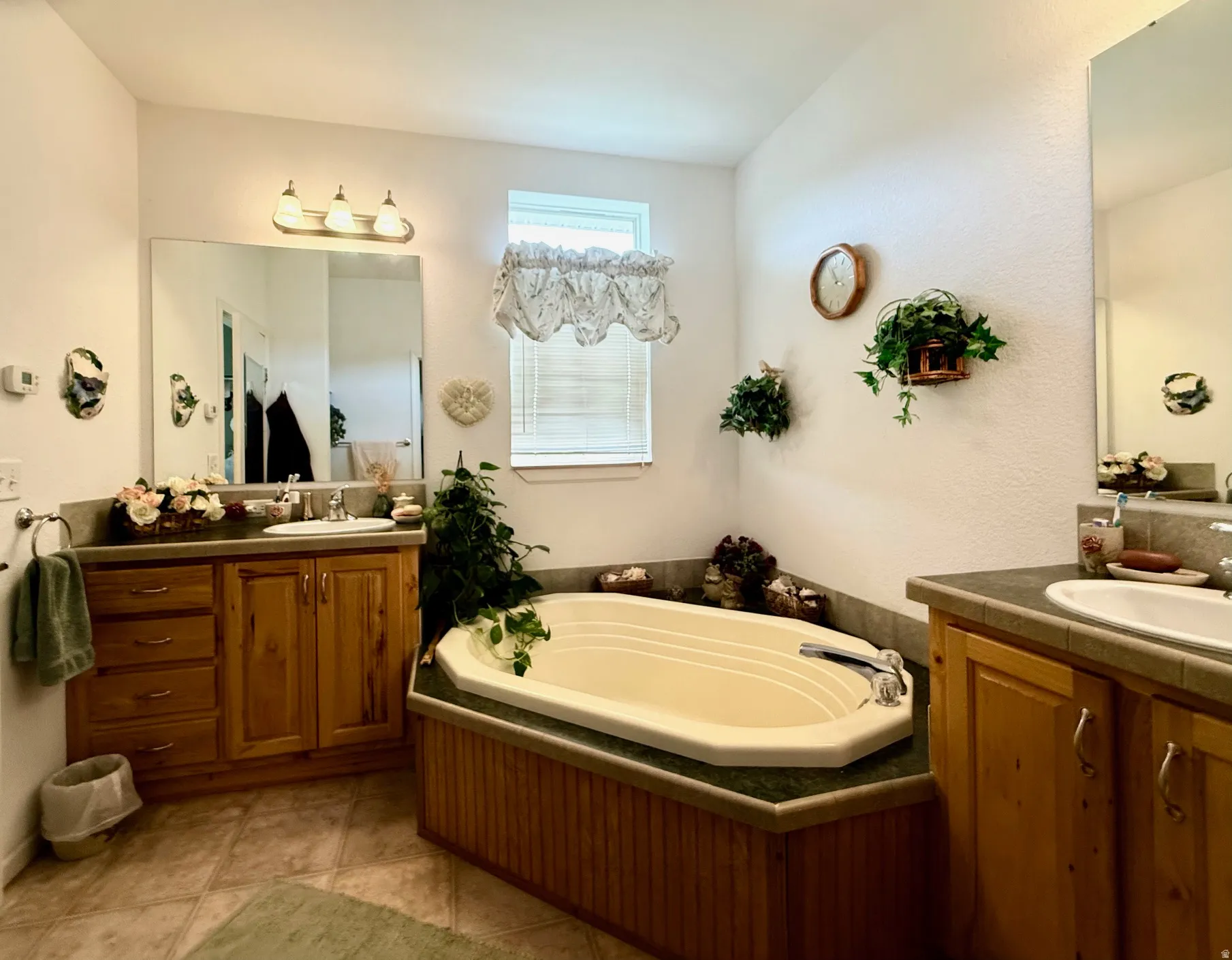Full bathroom featuring two vanities and a garden tub