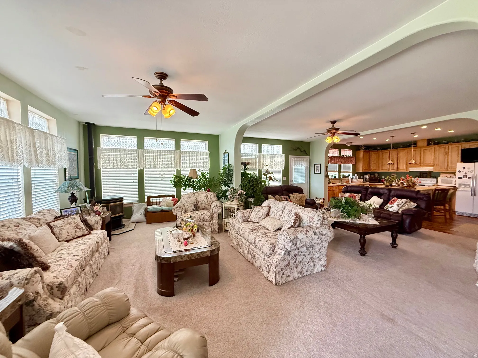 Living room with ceiling fan, light colored carpet, and recessed lighting