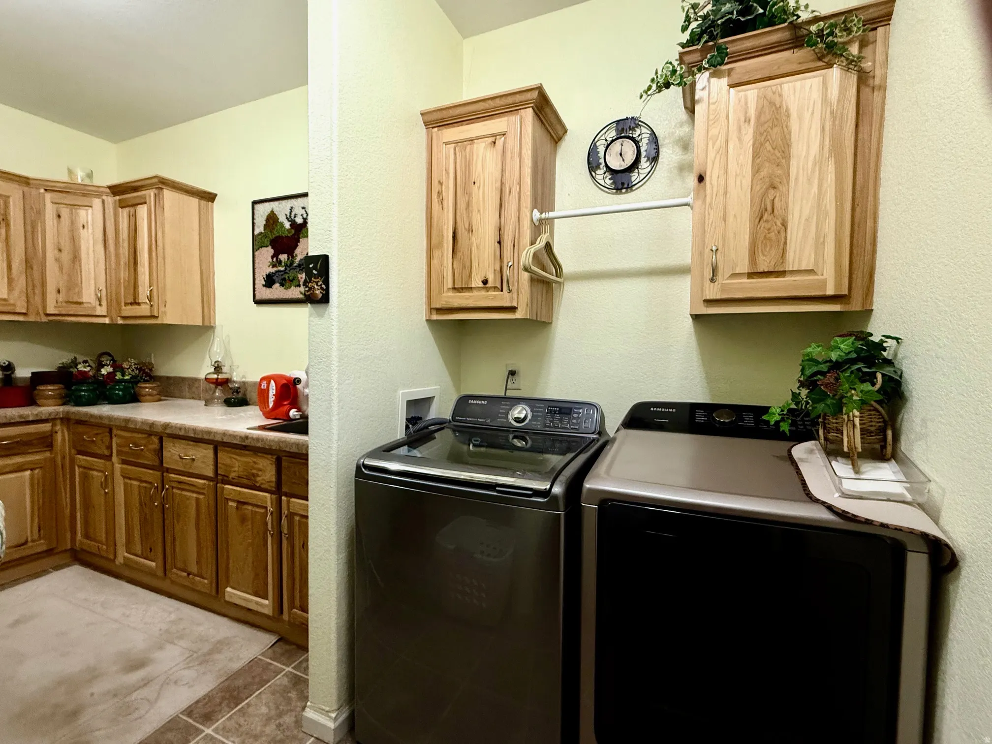 Laundry room with cabinet space, light tile patterned flooring, separate washer and dryer, and a textured wall