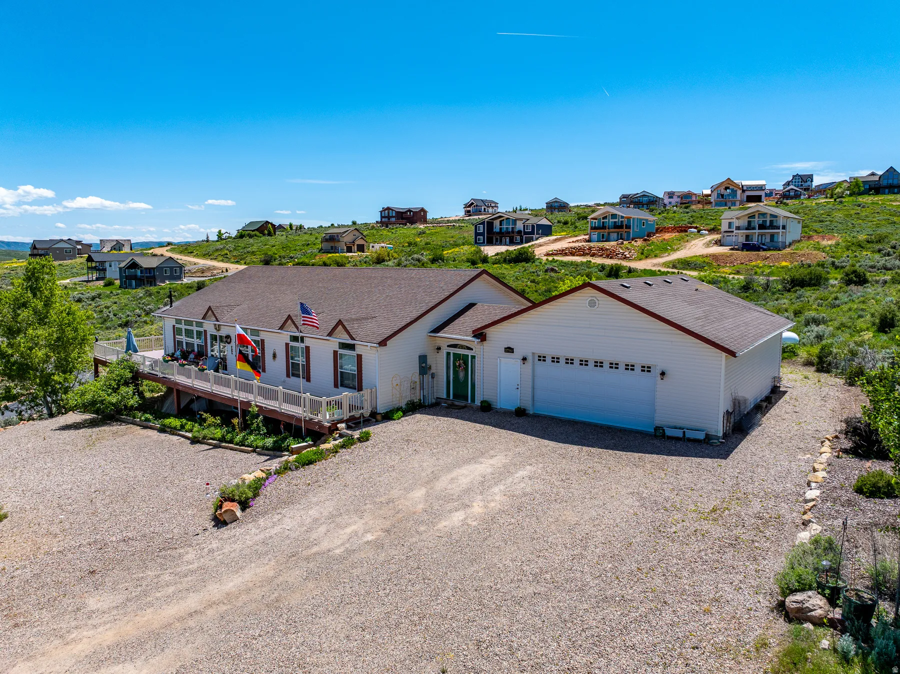 Single story home featuring gravel driveway, a shingled roof, and a residential view