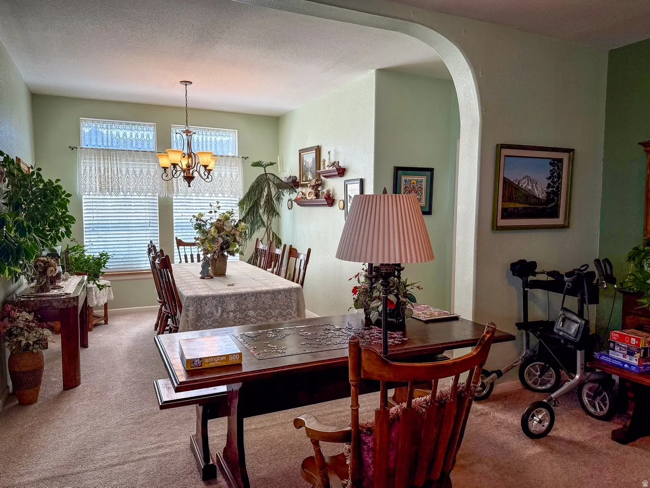 Dining area with light carpet, suspended lighting, and arched walkways