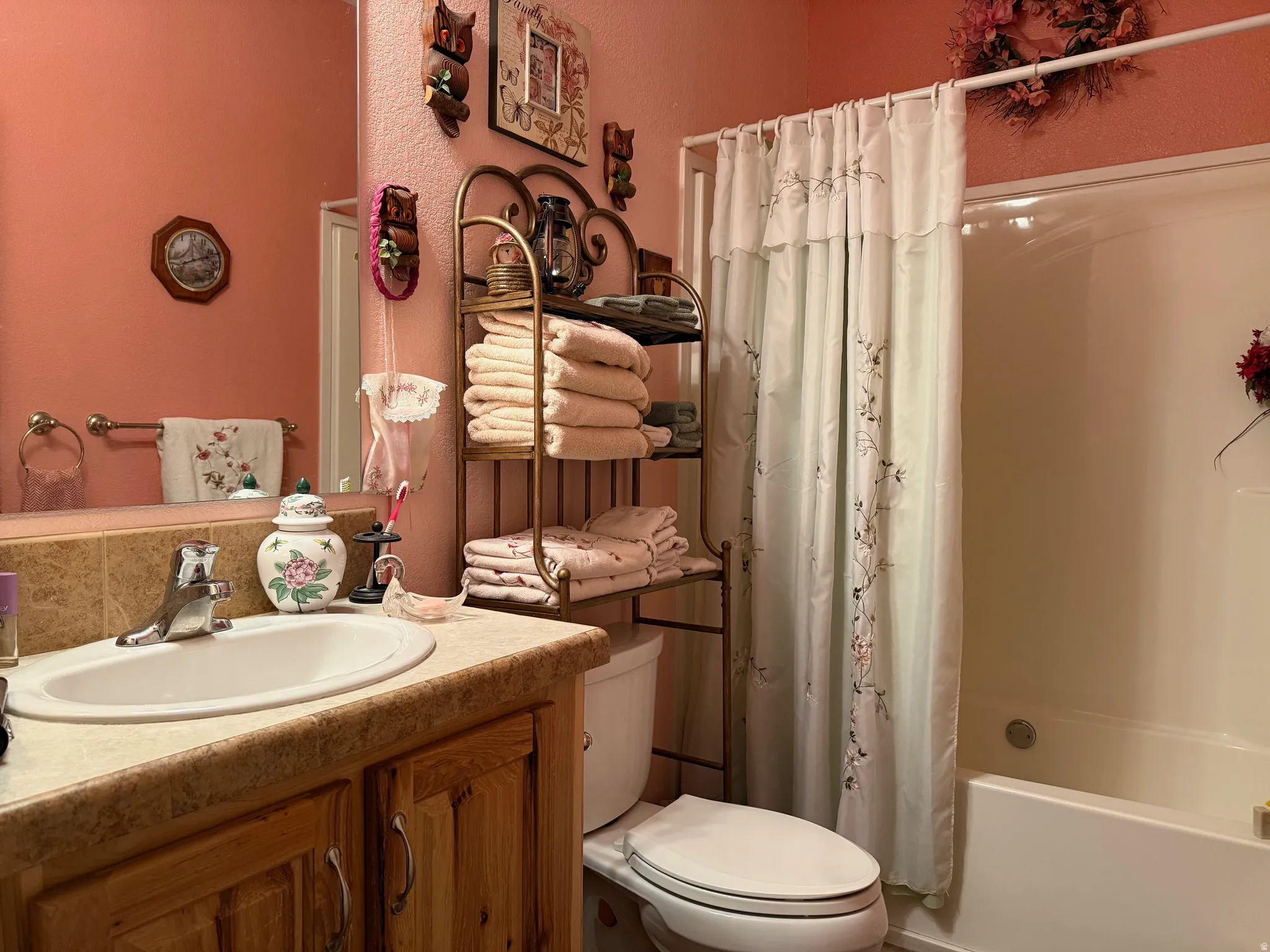 Full bath with vanity, shower / bathtub combination with curtain, and a textured wall