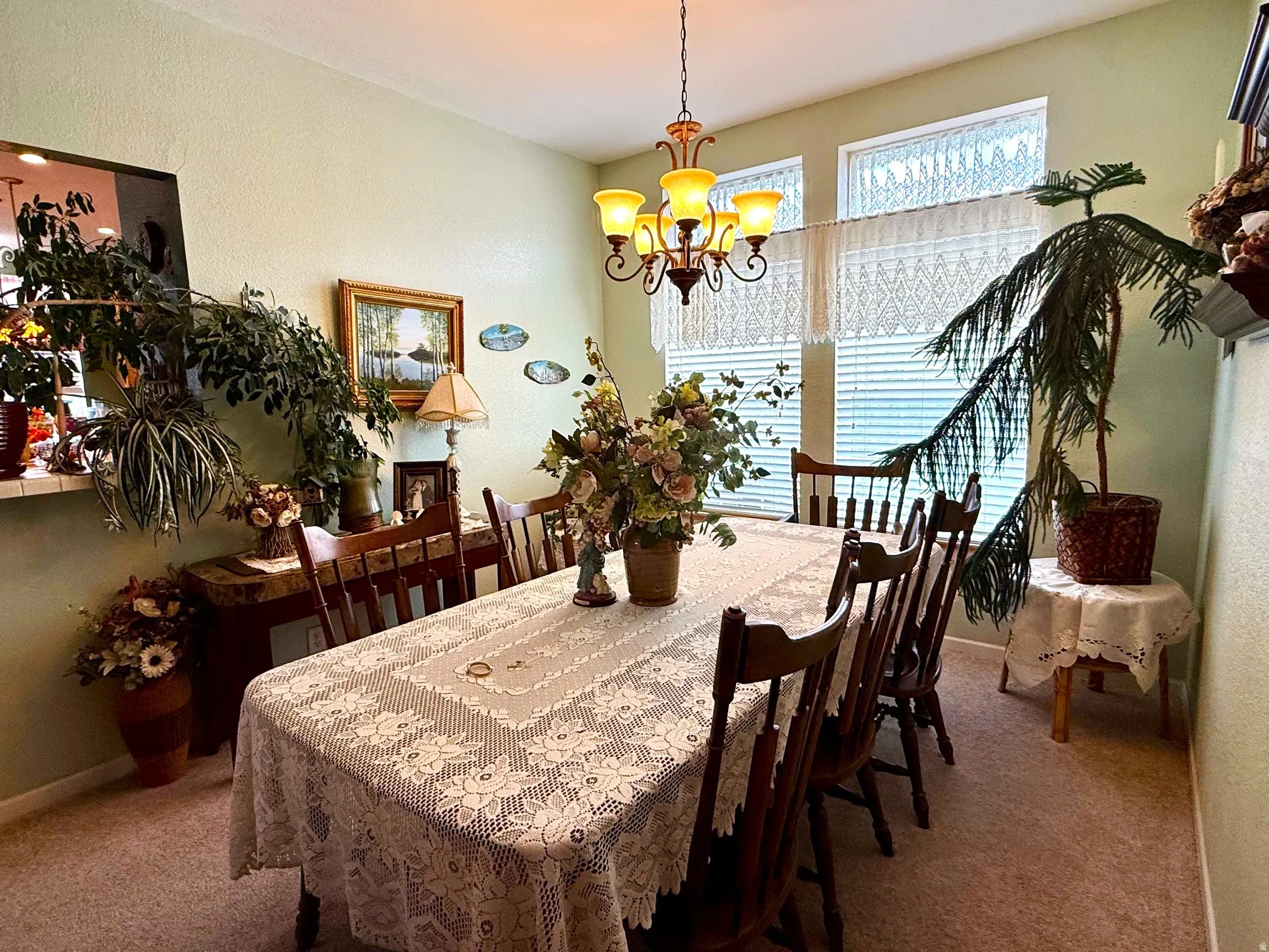 Dining room with carpet floors, a chandelier, and a textured wall