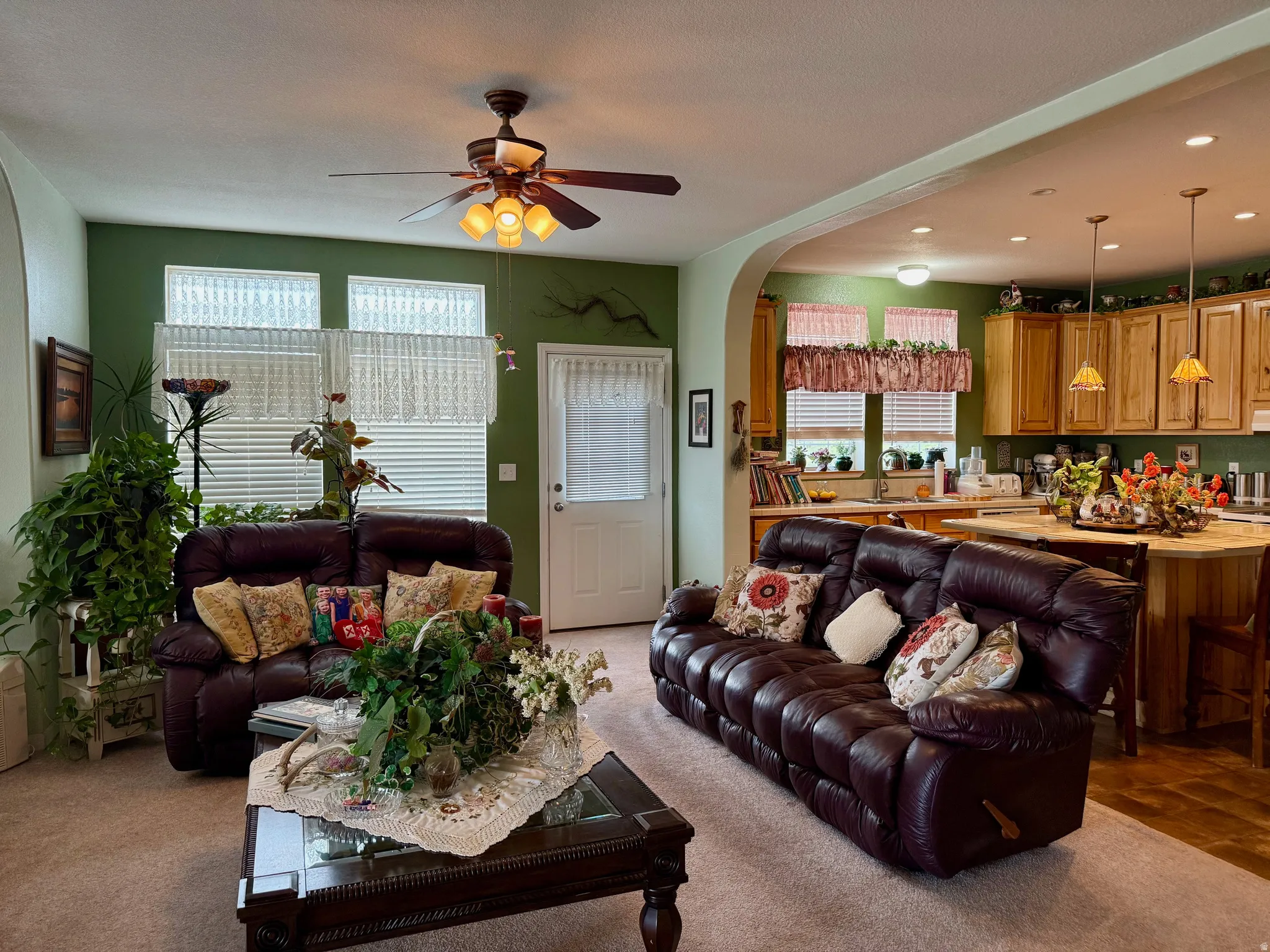 Living room featuring arched walkways, ceiling fan, recessed lighting, and light colored carpet
